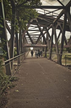 Group of teens walking down an old steel bridge in the Ruhr district of Germany