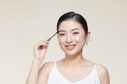 Makeup artist combs eyebrows in a beauty salon.