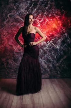 gorgeous sexy woman in evening dress posing over dark background