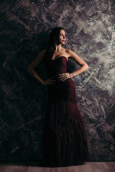 gorgeous sexy woman in evening dress posing over dark background
