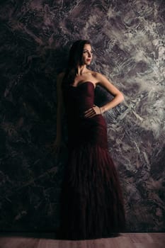 gorgeous sexy woman in evening dress posing over dark background