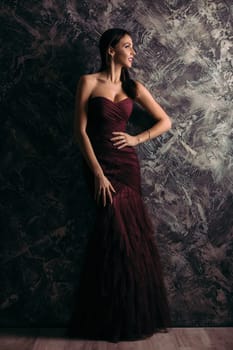 gorgeous sexy woman in evening dress posing over dark background