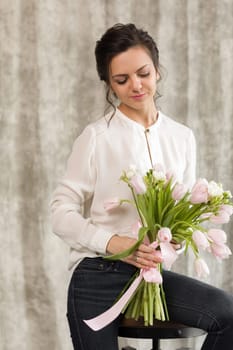 portrait of a beautiful brunette woman with a bouquet of tulips flowers