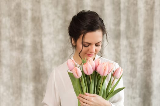 portrait of a beautiful brunette woman with a bouquet of tulips flowers