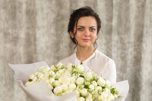 portrait of a beautiful brunette woman with a bouquet of tulips flowers