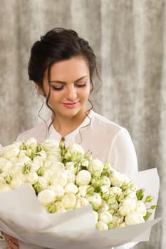 portrait of a beautiful brunette woman with a bouquet of tulips flowers