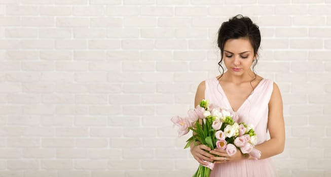 Portrait of beautiful bride with wedding bouquet of pink tulips