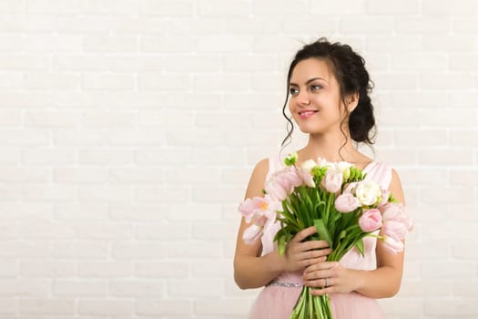 Portrait of beautiful bride with wedding bouquet of pink tulips
