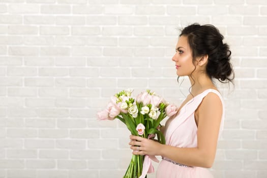 Portrait of beautiful bride with wedding bouquet of pink tulips