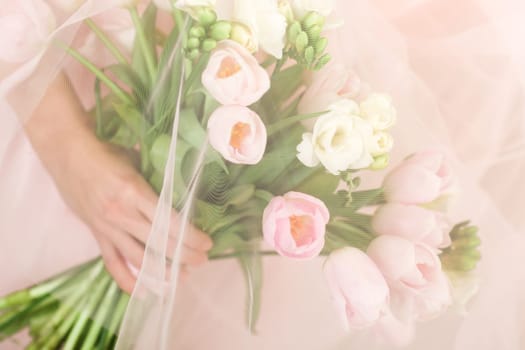 Wedding bouquet of pink tulips in bride's hands