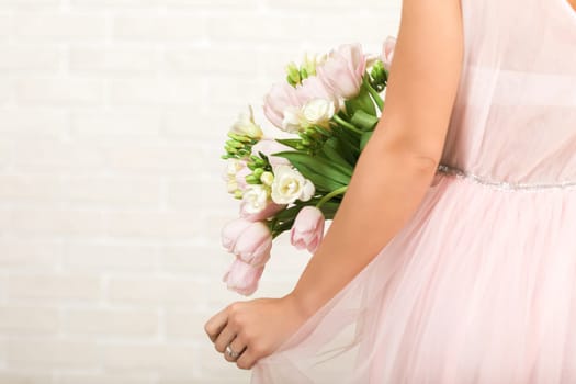 Wedding bouquet of pink tulips in bride's hands