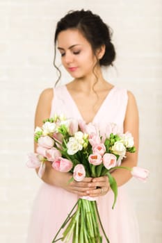 Portrait of beautiful bride with wedding bouquet of pink tulips