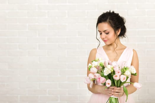 Portrait of beautiful bride with wedding bouquet of pink tulips