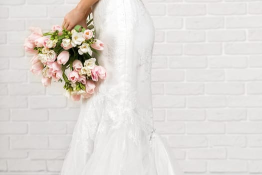 Wedding bouquet of pink tulips in bride's hands