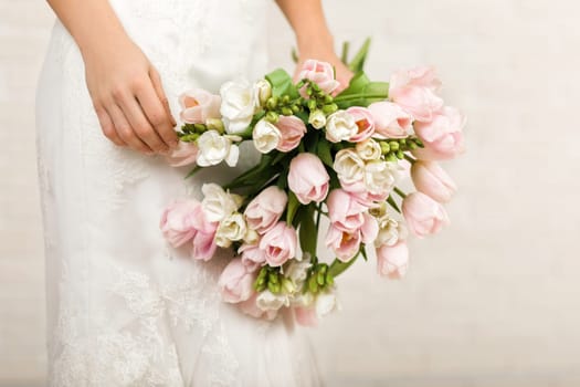 Wedding bouquet of pink tulips in bride's hands