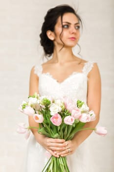 Portrait of beautiful bride with wedding bouquet of pink tulips