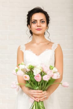 Portrait of beautiful bride with wedding bouquet of pink tulips