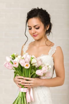 Portrait of beautiful bride with wedding bouquet of pink tulips