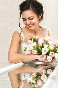 Portrait of beautiful bride with wedding bouquet of pink tulips
