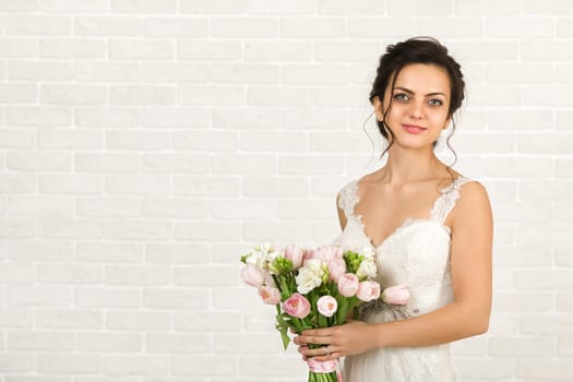 Portrait of beautiful bride with wedding bouquet of pink tulips