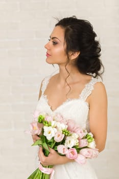 Portrait of beautiful bride with wedding bouquet of pink tulips