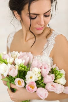Portrait of beautiful bride with wedding bouquet of pink tulips