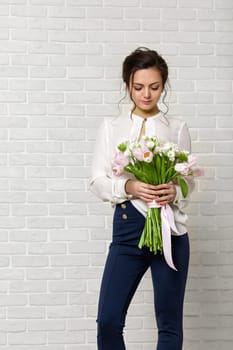 portrait of a beautiful brunette woman with a bouquet of tulips flowers