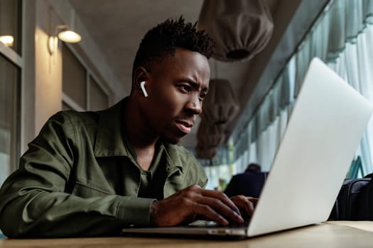 african american man using computer in cafe. young businessman working on his laptop