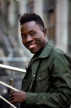 portrait of african-american man in stylish jacket on city street in the evening