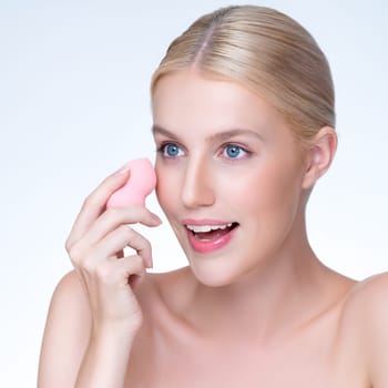 Closeup personable beautiful natural soft makeup woman using powder puff for facial makeup concept. Cushion foundation applying on young girl face in isolated background.