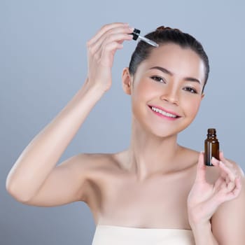 Glamorous portrait of beautiful woman applying extracted cannabis oil bottle for skincare product. CBD oil dropper pipette for cosmetology treatment and cannabinoids concept in isolated background.