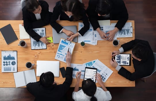 Top-view business team of financial data analysis meeting with business intelligence, report paper and dashboard on laptop for marketing strategy. Business people working together in office of harmony