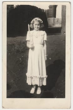 THE CZECHOSLOVAK SOCIALIST REPUBLIC - CIRCA 1950s: Vintage photo shows girl after her first communion. Retro black and white photography. Circa 1950s.