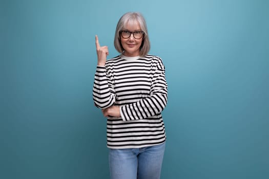 portrait of a brilliant smart old 60s woman with gray hair in a youthful look on a bright studio background.