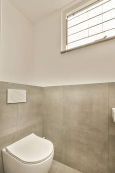 a white toilet in a bathroom with tile on the floor and walls, along with a window that looks out to the outside