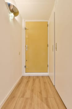 an empty room with yellow door and wooden floor in the corner, looking towards the entrance to the living room