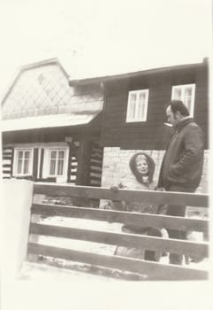 THE CZECHOSLOVAK SOCIALIST REPUBLIC - CIRCA 1970s: Vintage photo shows people in front of house. Retro black and white photography. Circa 1970s.