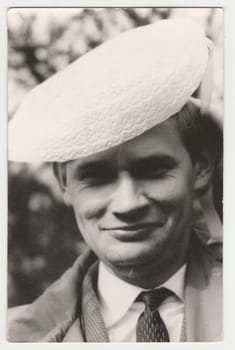 THE CZECHOSLOVAK SOCIALIST REPUBLIC - JULY 1979: Vintage photo shows man wears funny hat. Black and white retro photography. Circa 1980s.