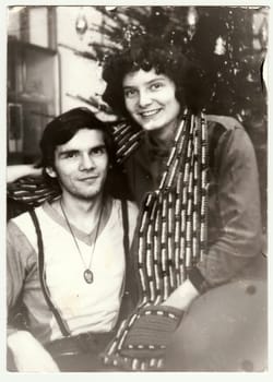 THE CZECHOSLOVAK SOCIALIST REPUBLIC - CIRCA 1980s: Vintage photo shows an adolescent couple during Christmas. Retro black and white photography. Circa 1980s.