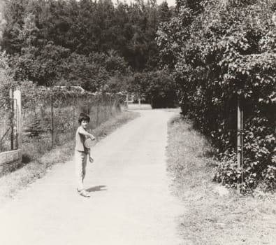 THE CZECHOSLOVAK SOCIALIST REPUBLIC - CIRCA 1980s: Vintage photo shows a small boy holds Frisbee. Retro black and white photography. Circa 1980s.