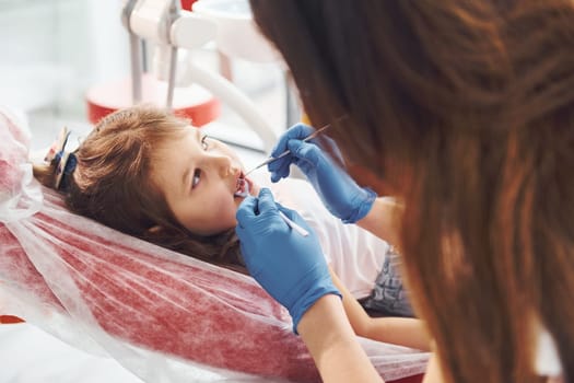 Little girl visiting dentist in clinic. Conception of stomatology.