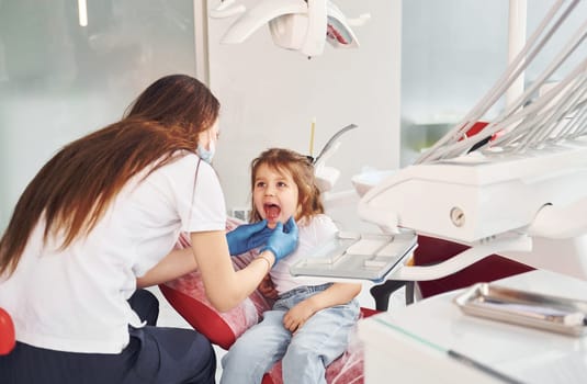 Little girl visiting dentist in clinic. Conception of stomatology.