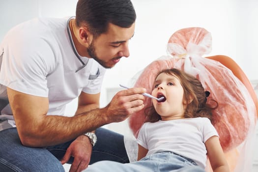 Little girl visiting dentist in clinic. Conception of stomatology.