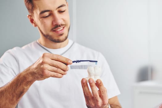 Portrait of professional dentist with equipment that standing indoors.