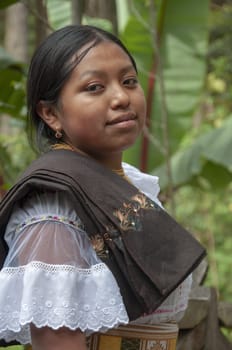 CLOSE UP of indigenous looking at the camera with a banana tree in the background and dressed in traditional dress. High quality photo