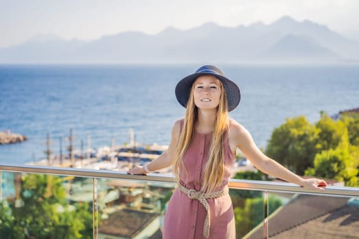 Woman tourist in Old town Kaleici in Antalya. Turkiye. Panoramic view of Antalya Old Town port, Taurus mountains and Mediterrranean Sea, Turkey.