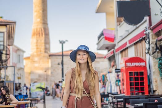 Happy woman tourist on background of old street of Antalya. female tourist traveler discover interesting places and popular attractions and walks in the old city Kalechi of Antalya, Turkey. Turkiye.