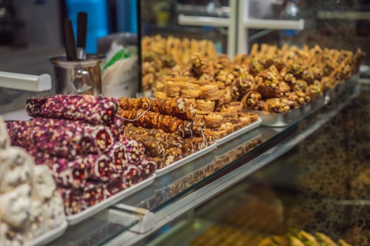 Traditional oriental sweet pastry cookies, nuts, dried fruits, pastilles, marmalade, Turkish desert with sugar, honey and pistachio, in display at a street food market.