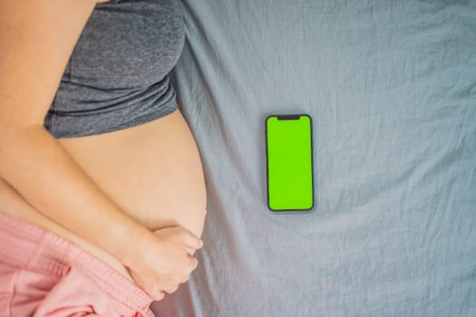Pregnant girl with a smartphone. The concept of a negative impact on the unborn child in the womb. Violation of the nervous system of the child, reproductive.