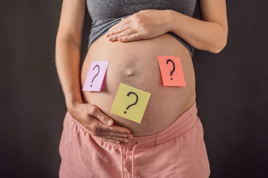 Choosing baby name. Confused pregnant woman with question marks on paper stickers on tummy.